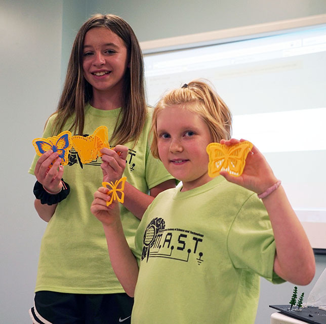 students holding butterflies made with 3D printer 
