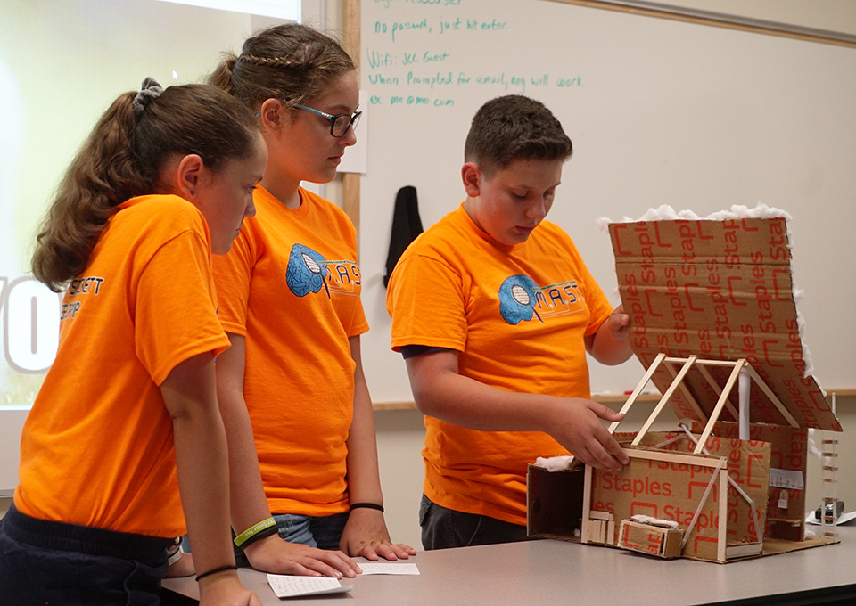 students showing their sugar shack prototype 