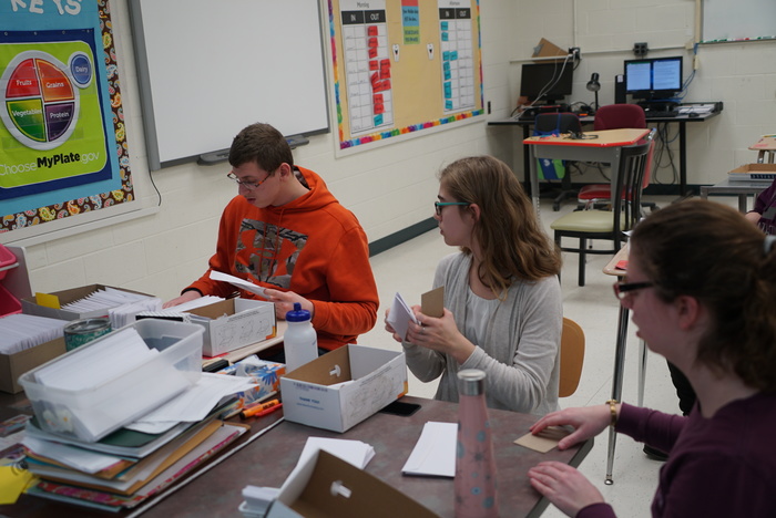 Students folding documents for mailing 