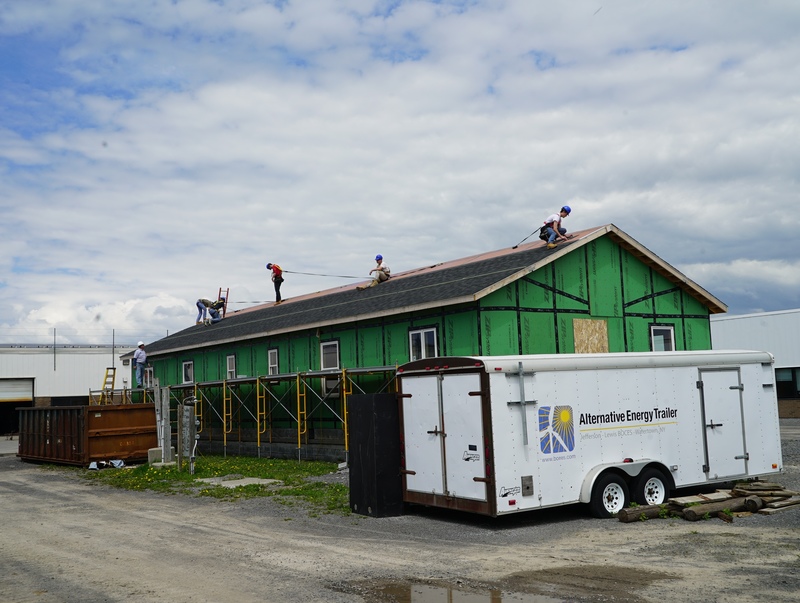 Students installing roof on duplex