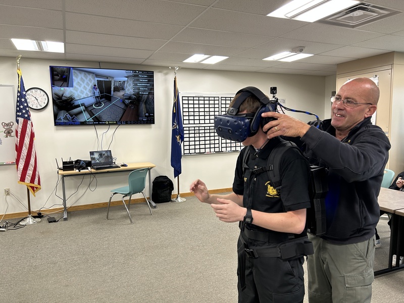 Mr. Gorman fits VR headset on student